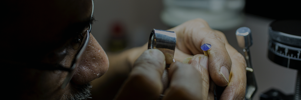 About Us - Looking at a gemstone through a loupe